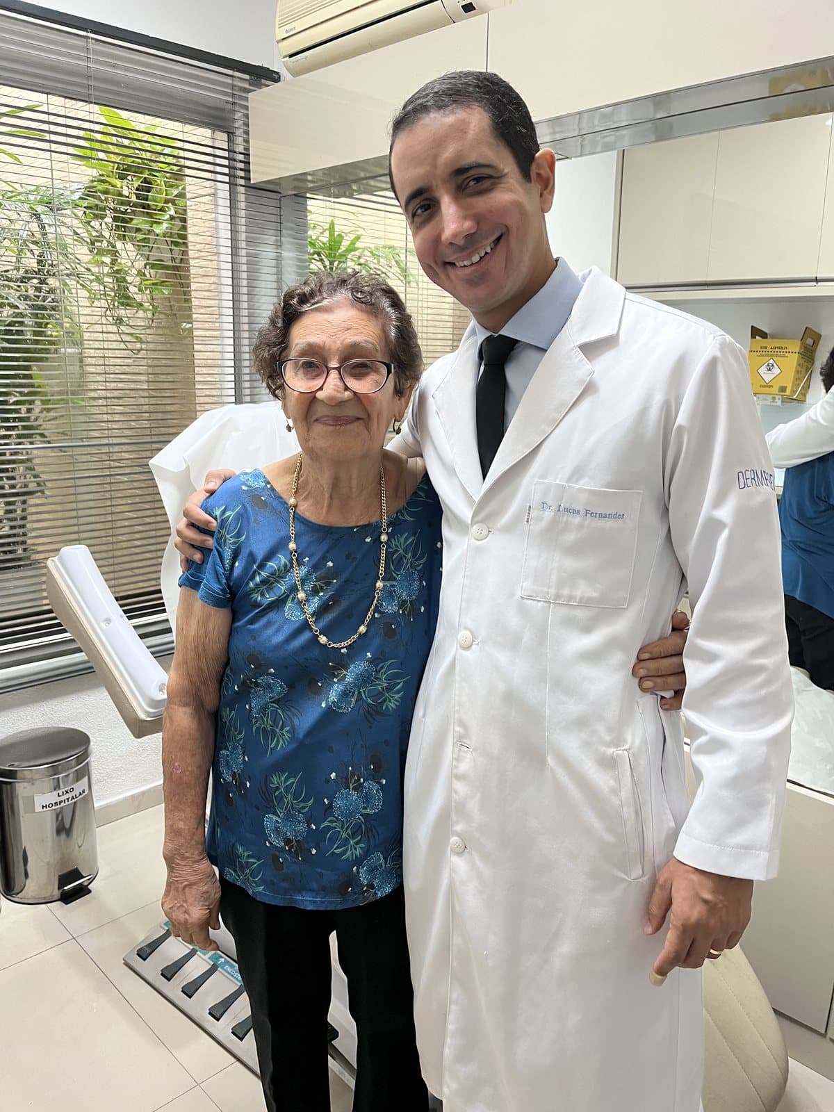 Dr. Lucas Fernandes ao lado de uma paciente no consultório